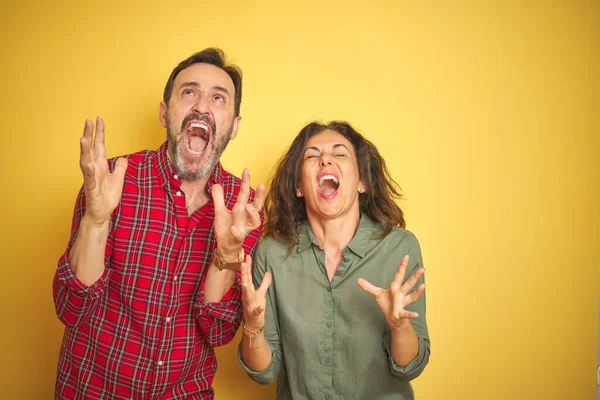 Belo Casal Meia Idade Sobre Fundo Amarelo Isolado Louco Louco — Fotografia de Stock