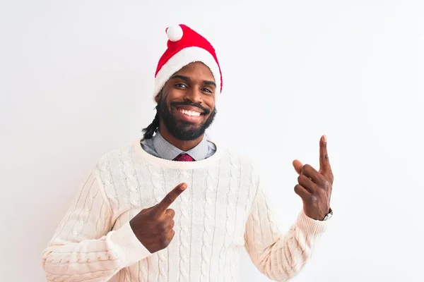 若いですアフリカ系アメリカ人男性身に着けていますクリスマスの帽子隔離された白い背景笑顔とカメラを見て2本の手と指で側面を指して — ストック写真
