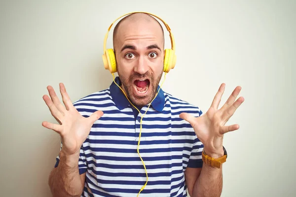 Mladý Muž Který Poslouchá Hudbu Žlutými Sluchátky Izolovaném Pozadí Oslavuje — Stock fotografie