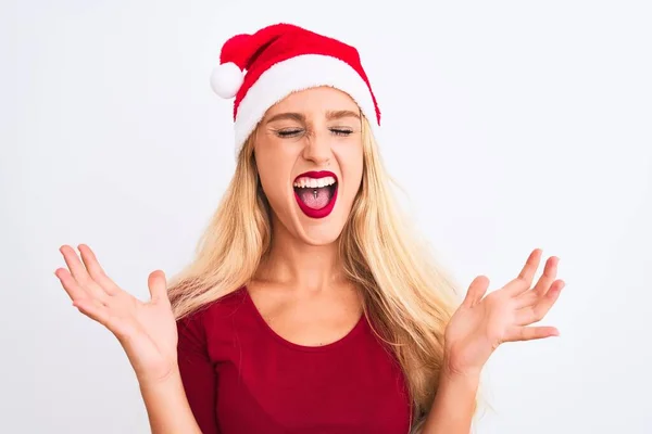 年轻美丽的女人戴着圣诞圣诞礼帽 在孤独的白色背景上欢庆着疯狂和疯狂的成功 举起双臂 闭上眼睛 兴奋地尖叫着 赢的概念 — 图库照片
