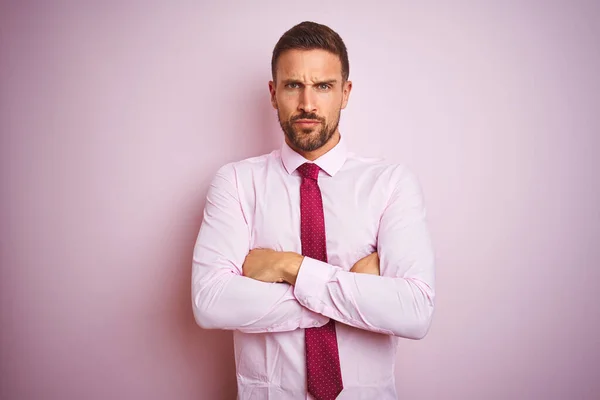 Business man wearing tie and elegant shirt over pink isolated background skeptic and nervous, disapproving expression on face with crossed arms. Negative person.