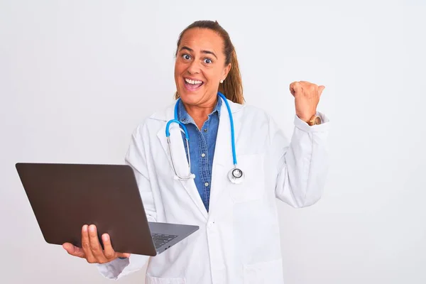 中年成熟した医師女性保持コンピュータラップトップ上の隔離された背景を指していると表示しますとともに親指で側まで幸せな顔笑顔 — ストック写真