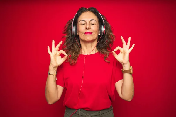 Middle Age Senior Woman Wearing Headphones Listening Music Red Isolated — ストック写真