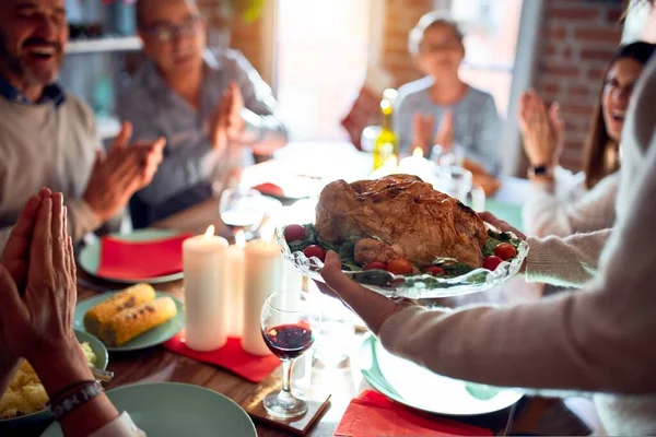 伝統的な料理と装飾でクリスマスの前夜を祝う家で家族や友人の食事 誇りに思って七面鳥料理を示す — ストック写真