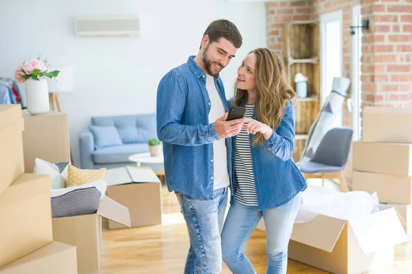 Pareja Joven Que Muda Una Casa Nueva Usando Teléfono Inteligente — Foto de Stock