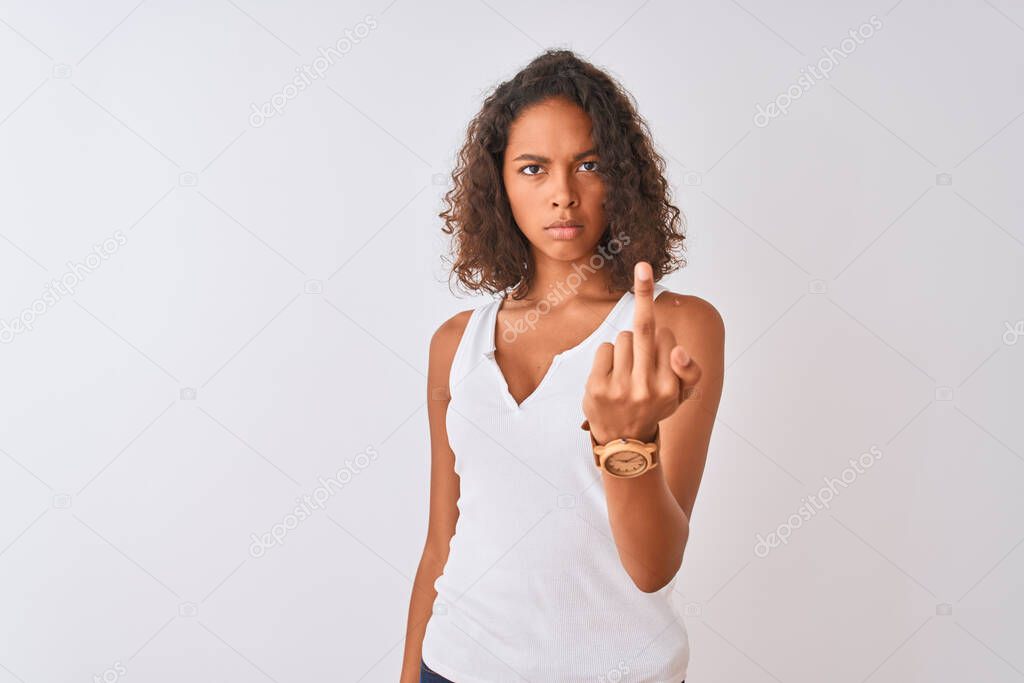 Young brazilian woman wearing casual t-shirt standing over isolated white background Showing middle finger, impolite and rude fuck off expression