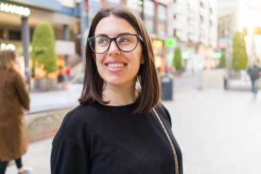 Güzel genç esmer kadın gülümsüyor heyecanlı yürürken 