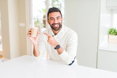 Bir kahve almak içerken gülümseyen yakışıklı adam 