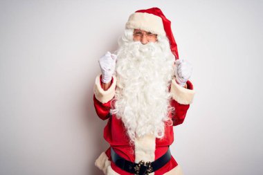 Noel Baba kostümü giymiş orta yaşlı yakışıklı bir adam izole edilmiş beyaz arka plan üzerinde duruyor. Kolları havada ve gözleri kapalı zaferi kutlarken gülümsüyor. Kazanan konsept.