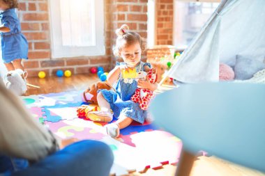 Anaokulunda bir sürü oyuncakla oynayan sevimli bir grup çocuk.
