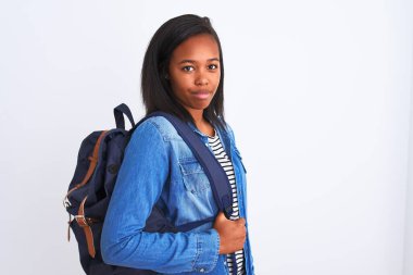 Sırt çantası takan Afrikalı Amerikalı genç bir bayan. Tecrit edilmiş bir geçmişe sahip. Akıllı bir yüz ifadesi var.