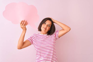 İzole edilmiş pembe arka planda duran bulutlu konuşma baloncuğu tutan genç ve güzel bir kadın. Elleri havada, utançla ve şaşkınlık dolu, sinirli ve hayal kırıklığına uğramış bir halde. Hata için korku ve üzüntü.