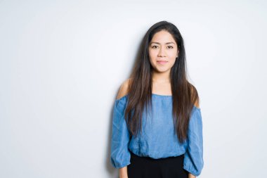 Yüzünde ciddi bir ifade ile izole arka plan güzel esmer kadın. Basit ve doğal kameraya bakıyor.