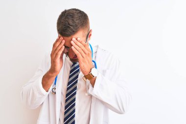 Soyutlanmış arka planda steteskop takan yakışıklı genç bir doktor. Ağlarken suratını ellerle kapatan üzgün bir ifade. Depresyon kavramı.