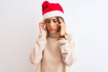 Güzel kızıl saçlı kadın, izole edilmiş arka plan üzerinde noel şapkası takıyor ve baş ağrısı çekiyor çünkü stres var. Migren ağrısı..