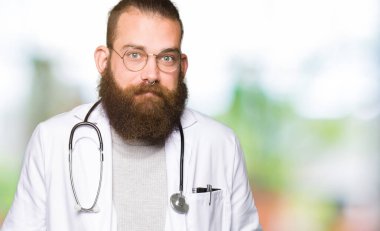 Genç sarışın doktor tıbbi kat clueless ve şaşkın bir ifadeyle kollar ve eller kaldırdı giyen sakallı adam. Şüphe kavramı.