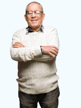 Gözlük ve kış kazağı giyen yakışıklı yaşlı adam mutlu yüz kameraya bakarak çapraz kolları ile gülümseyerek. Pozitif kişi.