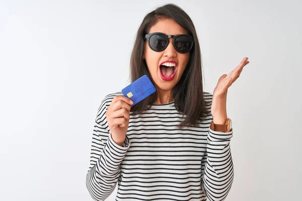 Młoda Chinka Okularach Przeciwsłonecznych Kartą Kredytową Białym Tle Bardzo Szczęśliwy — Zdjęcie stockowe