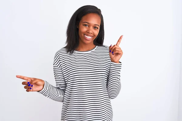 孤立した背景に冬のセーターを着た美しい若いアフリカ系アメリカ人女性は さまざまな方向に指で自信を持って指して笑っています 広告のコピースペース — ストック写真
