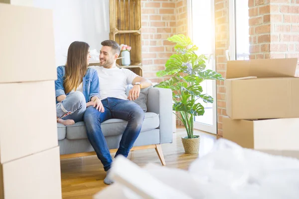 Pareja joven en el amor relajante sentado en el sofá en el nuevo hogar, s — Foto de Stock