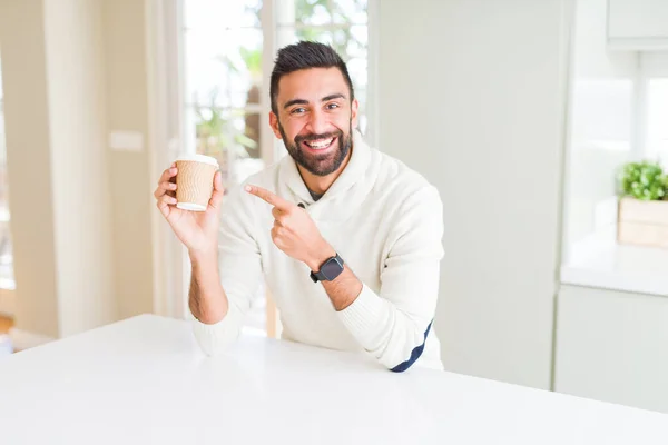 Hombre guapo sonriendo mientras disfruta bebiendo un café para llevar — Foto de Stock