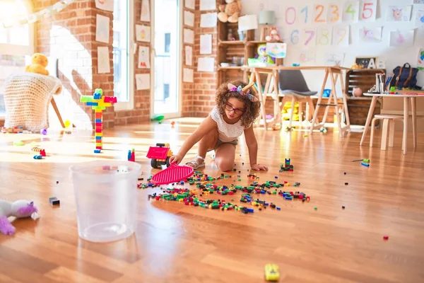 幼稚园漂亮的幼儿 戴着眼镜 骑着独角兽 玩拖拉机 积木玩具和网球拍 — 图库照片
