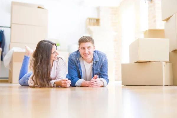 Joven hermosa pareja relajante tumbado en el suelo alrededor de cardbo — Foto de Stock