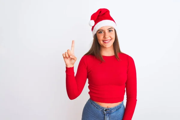 年轻美丽的女孩戴着圣诞圣诞圣诞礼帽 站在孤独的白色背景上 带着第一指尖 面带微笑 自信而快乐 — 图库照片