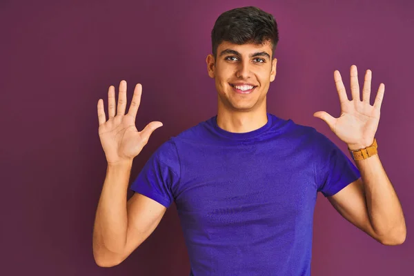 Молодой Индиец Футболке Стоит Изолированном Фиолетовом Фоне Показывает Пальцем Номер — стоковое фото