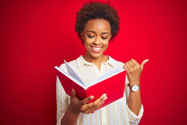Afroamerikansk Kvinna Läser Bok Över Röd Isolerad Bakgrund Pekar Och — Stockfoto