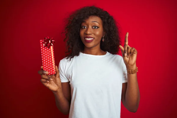 Junge Afrikanisch Amerikanische Frau Mit Valentinstagsgeschenk Vor Isoliertem Rotem Hintergrund — Stockfoto