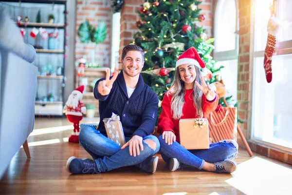 Casal Jovem Vestindo Chapéu Papai Noel Sentado Chão Torno Árvore — Fotografia de Stock