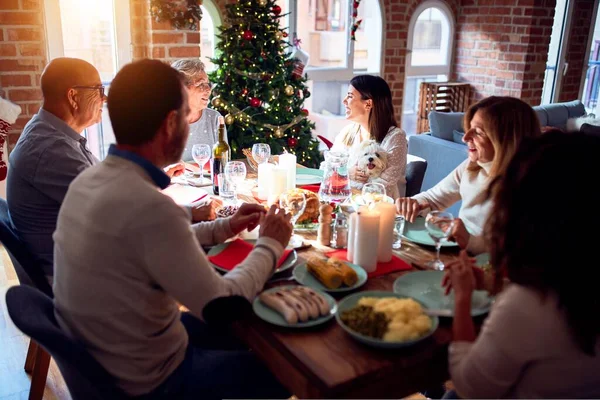 Family and friends dining at home celebrating christmas eve with traditional food and decoration, celebration of festive winter time