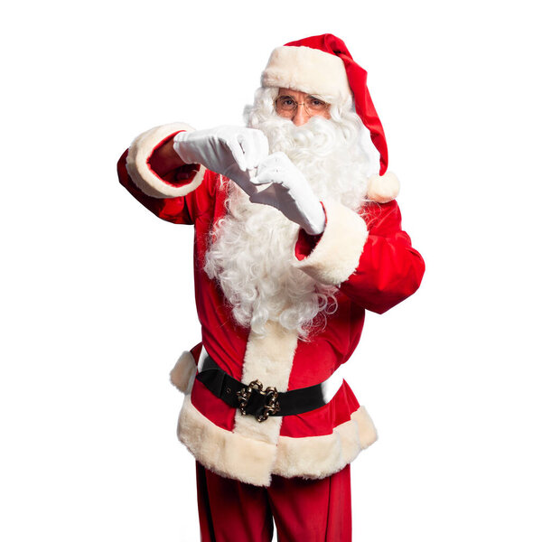 Middle age handsome man wearing Santa Claus costume and beard standing smiling in love doing heart symbol shape with hands. Romantic concept.
