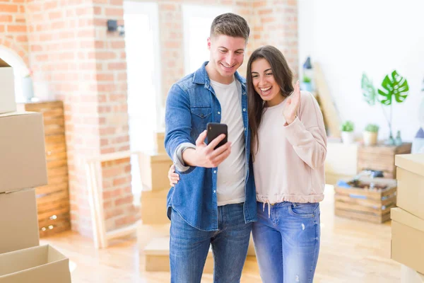 Belo Jovem Casal Mudando Para Uma Nova Casa Usando Smartphone — Fotografia de Stock