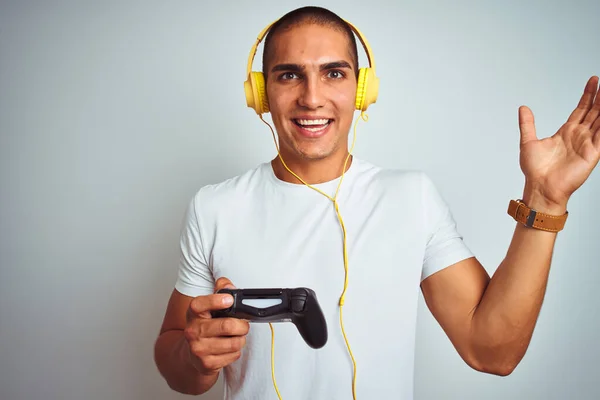 Mladý Pohledný Muž Hraje Videohry Pomocí Sluchátek Přes Bílé Izolované — Stock fotografie