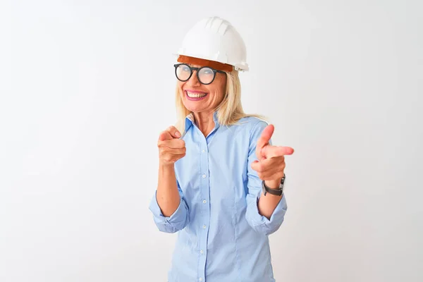 中年建筑师妇女戴着眼镜和头盔 戴在孤立的白色背景上 手指指向镜头 脸上洋溢着欢乐和滑稽的表情 好的能量和活力 — 图库照片