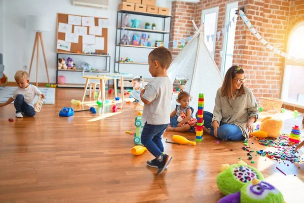 Vacker Lärare Och Grupp Småbarn Leker Runt Massor Leksaker Dagis — Stockfoto