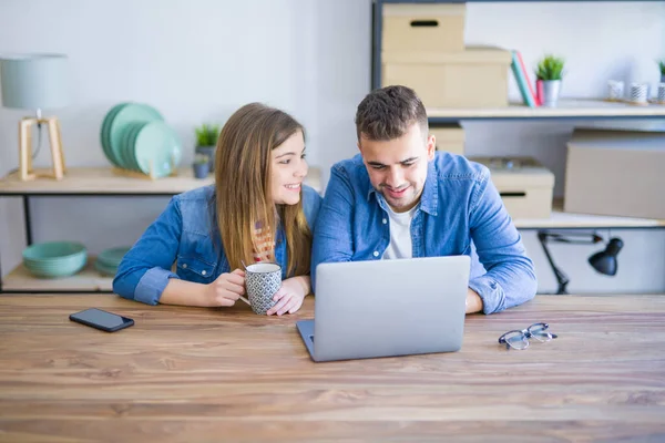 Pareja joven relajándose tomando un café y usando el ordenador l — Foto de Stock