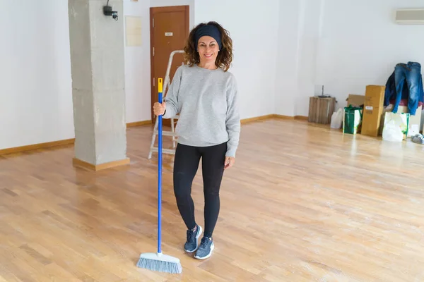 Femme d'âge moyen avec les cheveux bouclés de travail nettoyage de la maison usin — Photo