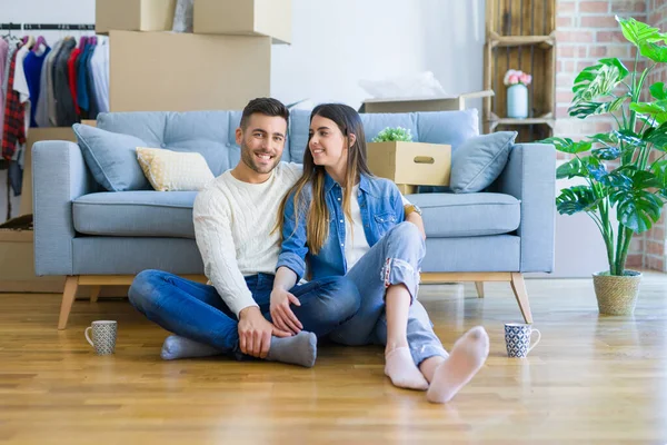 Молода красива пара сидить на підлозі нової квартири, см — стокове фото