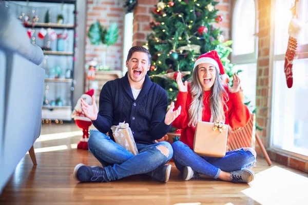 Casal Jovem Vestindo Chapéu Papai Noel Sentado Chão Torno Árvore — Fotografia de Stock