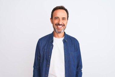 Yüzünde mutlu ve havalı bir gülümsemeyle izole edilmiş beyaz arka plan üzerinde duran mavi kot pantolon giyen orta yaşlı yakışıklı bir adam. Şanslı kişi..