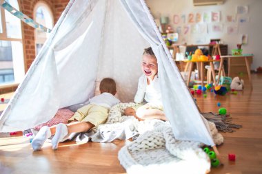 Anaokulunda bir sürü oyuncağın etrafında oynayan sevimli sarışın ikizler.