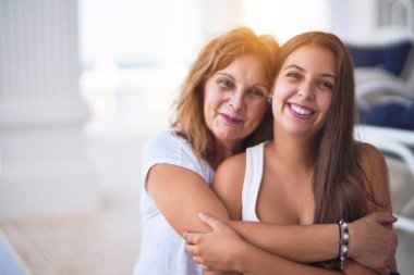 Güzel anne ve kız terasta mutlu bir yüzle sarılıyorlar.