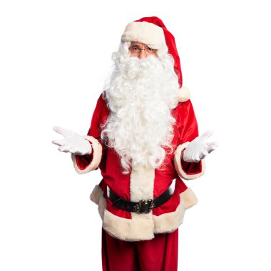 Orta yaşlı yakışıklı adam Noel Baba kostümü ve sakal takmış neşeli bir şekilde kollarını açıp gülümsüyor. Hoş geldin, olumlu ve kendinden emin selamlar.