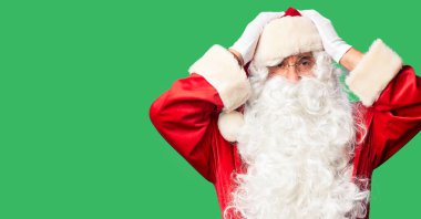 Orta yaşlı yakışıklı adam, Noel Baba kostümü ve sakal takıyor. Baş ağrısı yüzünden çaresiz ve stresli duruyor. Çünkü acı ve migren. Ellerini başının üstüne koy..