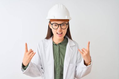 Genç Çinli mühendis kadın, izole edilmiş beyaz arka planda gözlük takıyor ve çılgın bir ifadeyle elleri havada rock sembolü yapıyor. Müzik yıldızı. Ağır konsept.