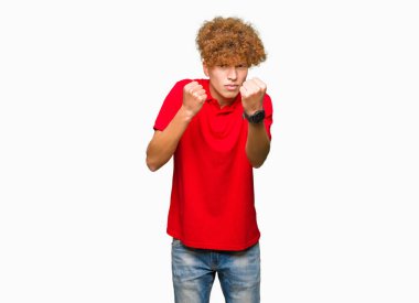 Kırmızı giyen afro saçlı yakışıklı delikanlı t-shirt yumruk savunma hareketi, kızgın ve üzgün yüz, sorunu korkuyor ile savaşmak için hazır