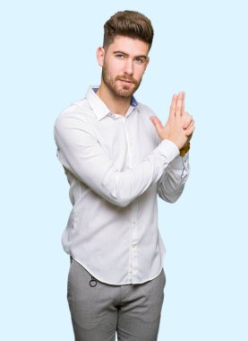 El hareketi ile sembolik silah tutan, çekim silah, kızgın yüz öldürme oynayan genç yakışıklı iş adamı